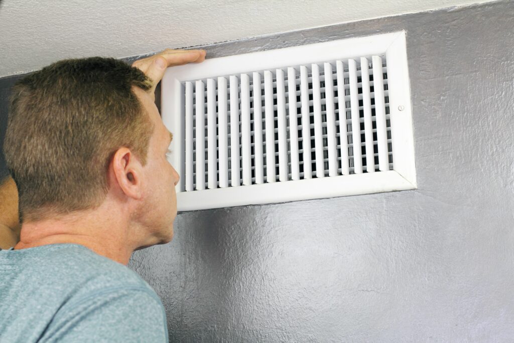 man looking at air duct
