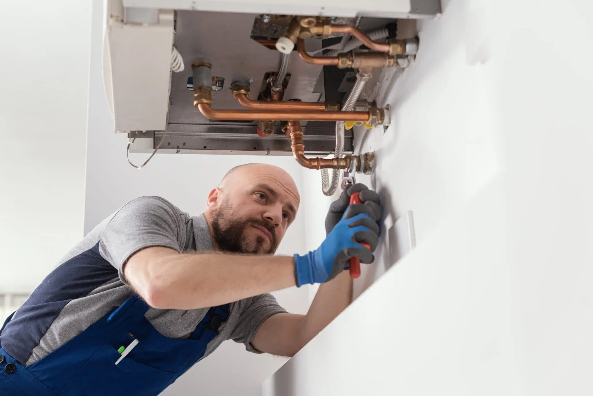 man under sink doing water heater installation