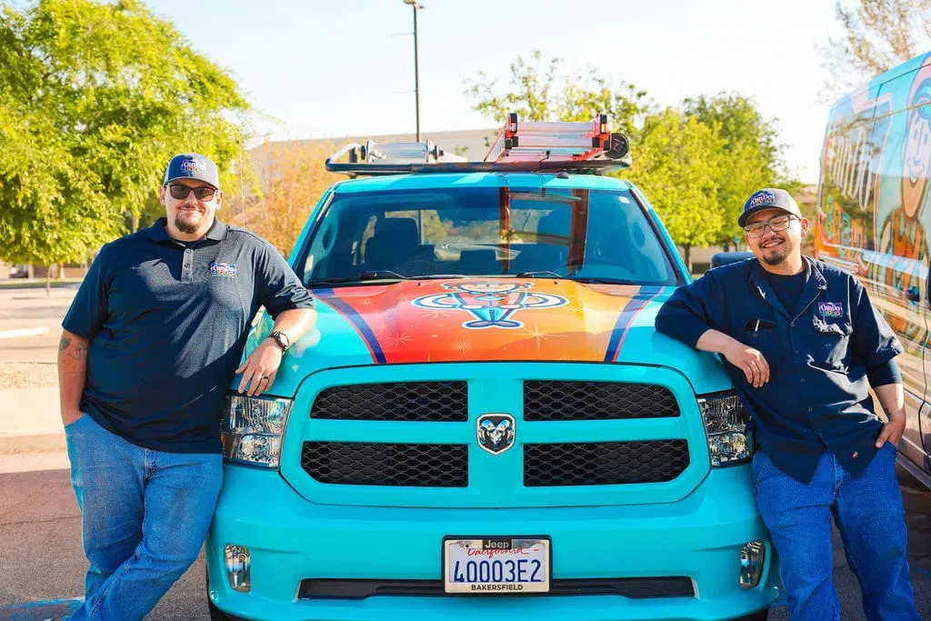 two men in front of work van