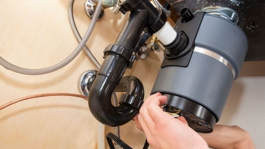Plumbing repairing garbage disposal unit.