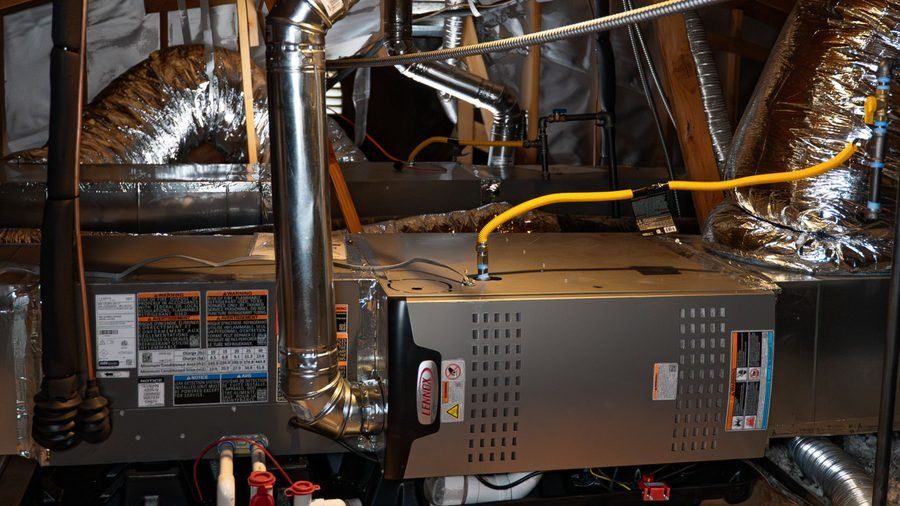 Lennox gas furnace installed in a residential attic with ductwork, vent piping, and gas connections.