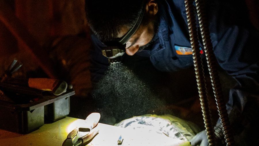 HVAC technician inspecting and servicing a residential furnace.