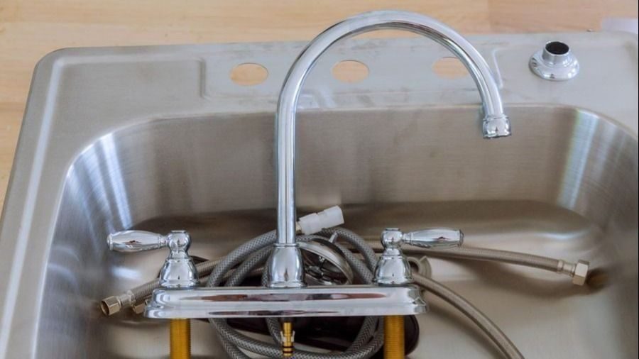 Faucet fixture sitting at bottom of sink before installation.